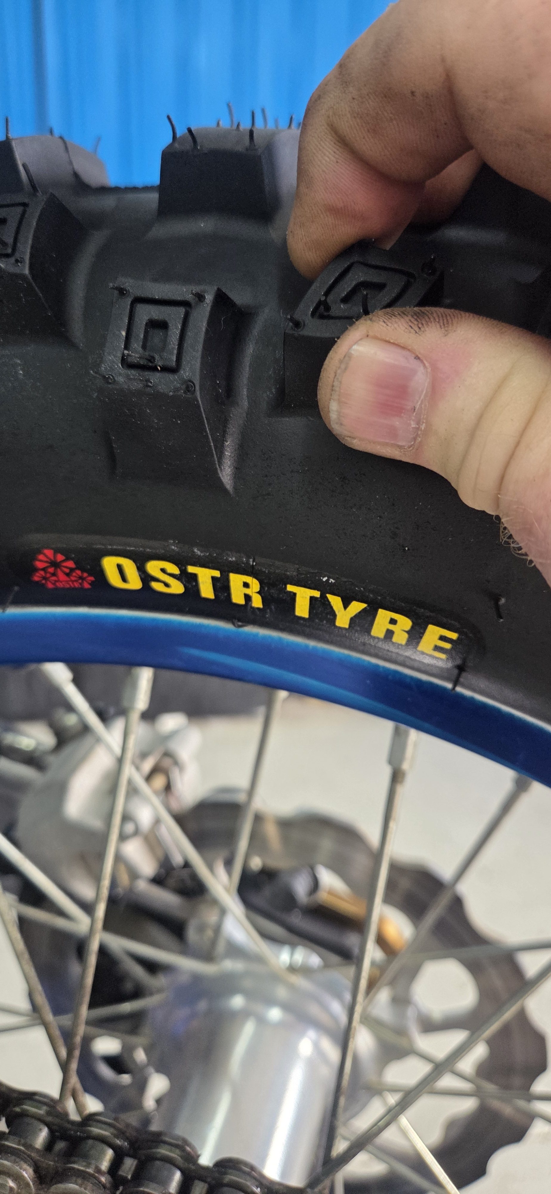 Close-up of soft gummy tyre tread flexing under hand pressure