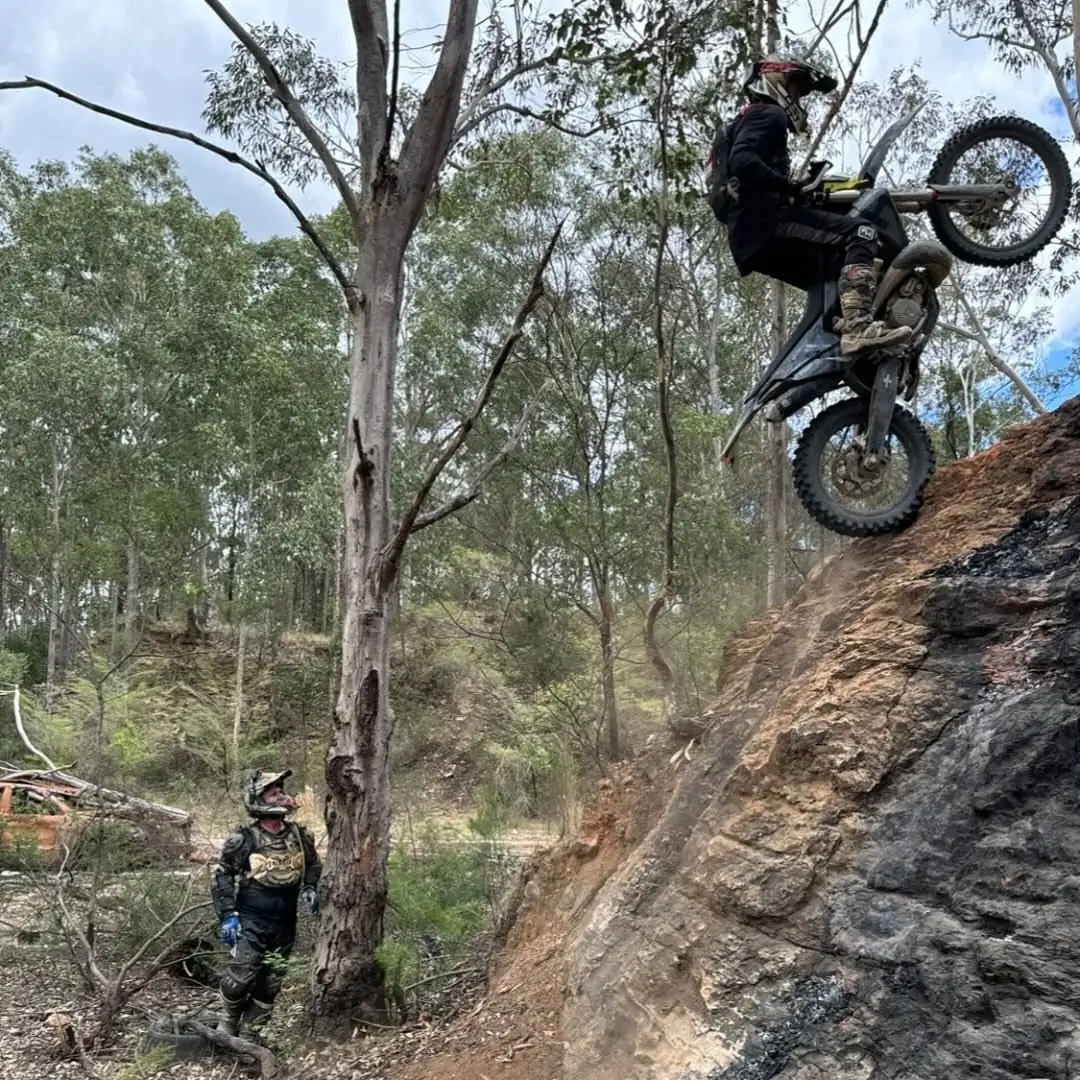 Hard enduro rider ascending a steep rocky climb in Australian bushland